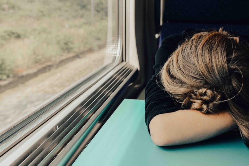 電車の中で昼寝をする女性